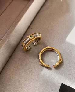 Close-up of vintage cable texture ring with green stones and gold embossed details