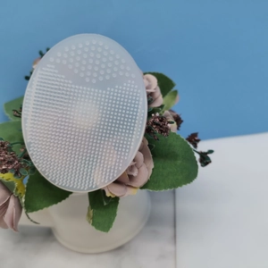 Macro detail of oval translucent silicone cleansing brush with soft massaging bristles
