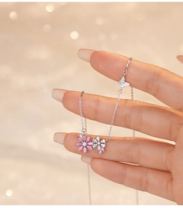 Close-up of S925 silver necklace featuring pink and white flowers with butterfly charm