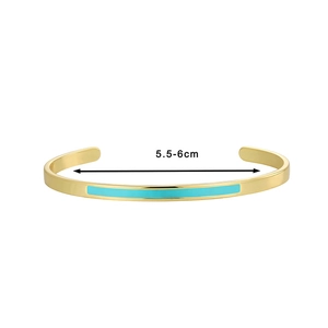 Detail view of gold open bracelet with turquoise enamel inlay and 5.5-6cm size marker