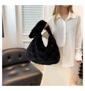 Fashionable black plush shoulder bag with checkered texture shown being carried by a model