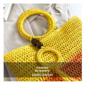 Detail of yellow hollow straw bag with round handle and decorative wooden beads