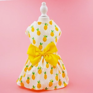 Detail of cream pet dress featuring yellow pineapple prints and a decorative satin bow