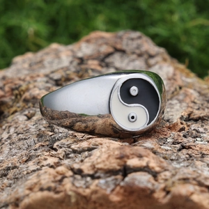 Silver stainless steel Tai Chi Yin Yang ring displayed on a natural bark surface