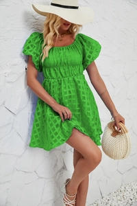 Gros plan détaillé sur une mini-robe verte à manches bouffantes et texture à carreaux