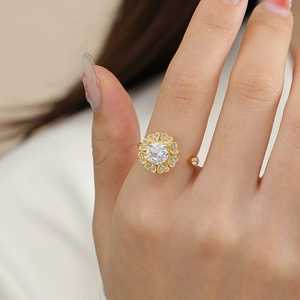 Macro shot of rotating flower ring with heart-shaped zirconia petals and adjustable golden band