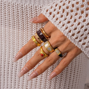 Close-up of stacked vintage gold-plated rings with brushed texture and crystal accents