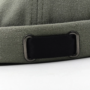 Détail de la sangle réglable en nylon noir et des oeillets sur la casquette en toile