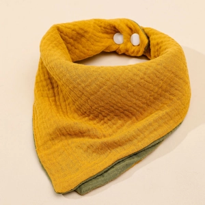 Detail of double-sided muslin cotton baby bib in mustard yellow and olive green colors