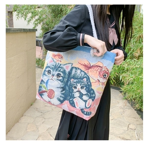 Detailed view of woven jacquard tote bag with cat and goldfish embroidery patterns