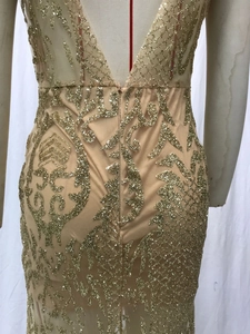 Detail of champagne gold sequins on luxury V-neck backless evening gown fabric