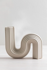 Detalle de jarrón cerámico crema con textura acanalada vertical y diseño ondulado