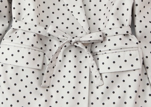 Détail de la taille du blazer à pois avec ceinture assortie et poches à rabat chic