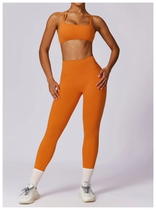 Front view of women orange yoga set including sports bra and high-waist leggings