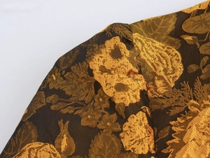 Macro-opname van elegante donkere jacquardstof met gouden bloemenborduursels en textuur