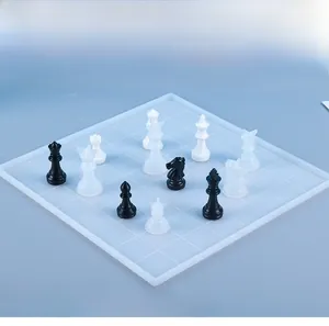 Macro view of glossy black and white resin chess pieces on a matte textured board