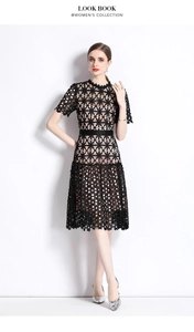 Détail d'une robe en dentelle noire brodée avec motif floral ajouré et ceinture
