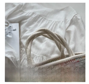 Detail of woven cotton rope handles and colorful zigzag patterns on the handmade bag