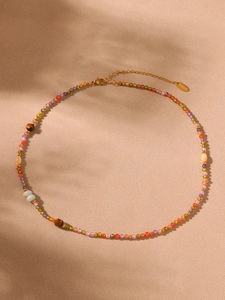 Detail of colorful faceted gemstones and tiger eye beads necklace with gold clasp