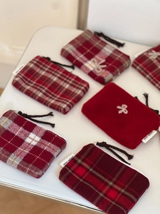 Macro shot of red plaid wool coin purses with embroidered bows and simple wish labels