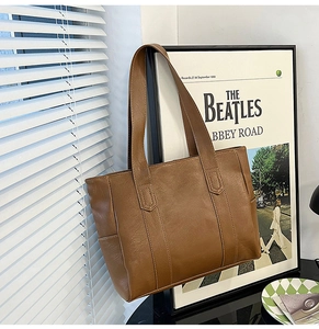 Detail view of the high-quality brown PU leather texture and stitching on the tote bag