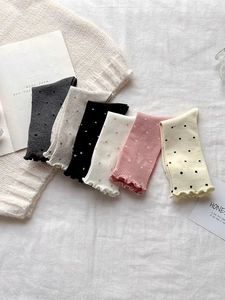 Detailed view of six colorful polka dot socks featuring elegant ruffle trim edges