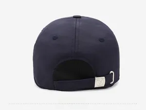 Detail view of the adjustable metal buckle and windproof fabric on a blue baseball cap