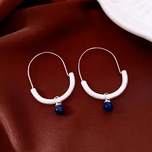 Vintage silver hoop earrings with tiger eye blue stone pendant on red silk background