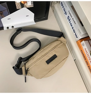 Close-up of beige nylon crossbody bag showing fabric texture and black zipper hardware