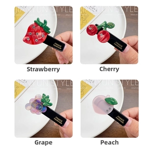 Detailed view of handmade fruit hair clips with sparkling rhinestones and acetate material