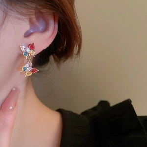 Detail shot of colorful zircon butterfly drop earrings with gold plating on model