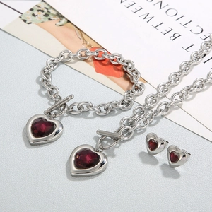 Detailed set of silver OT buckle jewelry featuring vibrant red heart crystal stones