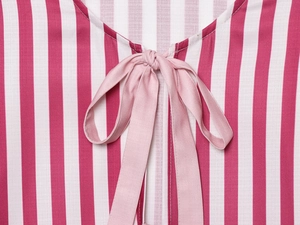 Détail du tissu à rayures rouges et blanches avec nœud rose sur le haut d'été tissé