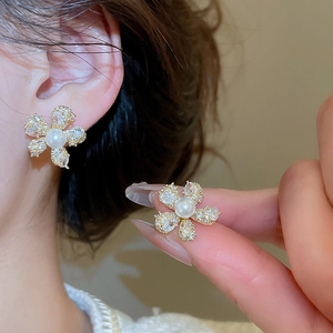 Detail eines fünfblättrigen Blumenohrrings mit Zirkonia und einer weißen Perle
