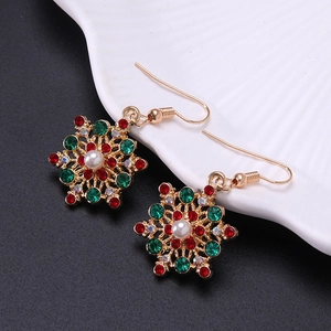 Macro shot of snowflake earrings with red green rhinestones and white pearl beads