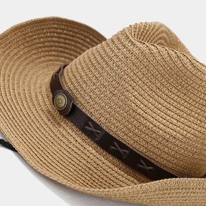 Detail of western straw hat featuring brown leather band with X-stitches and retro metal buckle