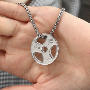 Detail of barbell pendant with engraved fitness slogan on a polished box chain