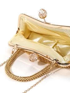 Detail of golden beaded clutch interior with luxury silk lining and crystal ball clasps