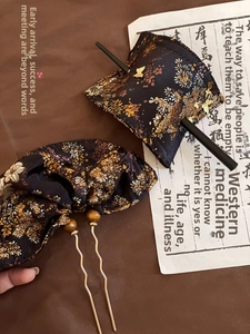 Detailed macro view of neo-Chinese fabric hairpins with golden floral embroidery patterns