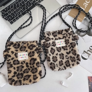Détail de mini sacs bandoulière en peluche léopard avec bandoulières tissées et bouton-pression