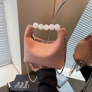 Elegant pink lychee leather handbag with white pearl handle and silver chain strap
