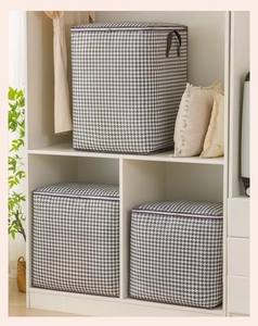 Close-up of houndstooth storage bags with zippers and side handles for clothes