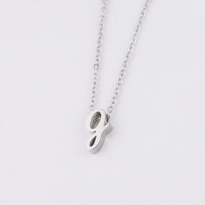 Détail d'un collier en acier inoxydable argenté avec pendentif en lettre g minuscule
