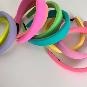 Macro shot of colorful padded sponge headbands showing various neon fabric colors and handmade labels