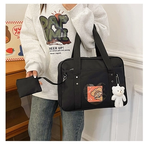 Detail of black Japanese JK uniform tote bag with heart window and plush bear charm
