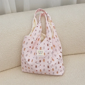 Close-up of pink embossed bubble fabric tote with Happy Bear prints and logo label