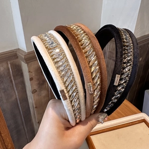 Détail des serre-têtes en velours avec strass brillants en beige, marron et noir classique