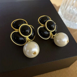 Macro shot of vintage floral earrings with black gemstones and large white pearls