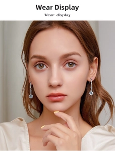 Elegant S925 sterling silver tassel earrings with moissanite on a model's ear