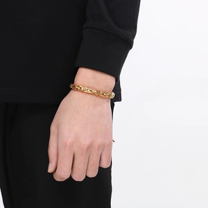 Detail of gold Byzantine chain bracelet for men worn on wrist over black sleeve garment
